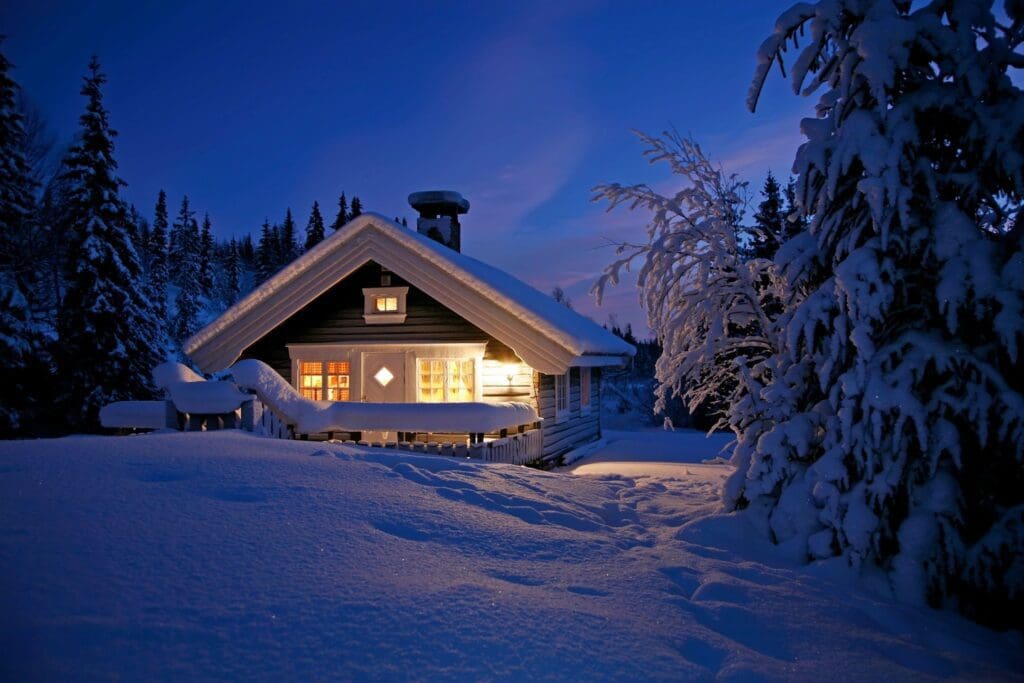 A house with snow on the ground and trees