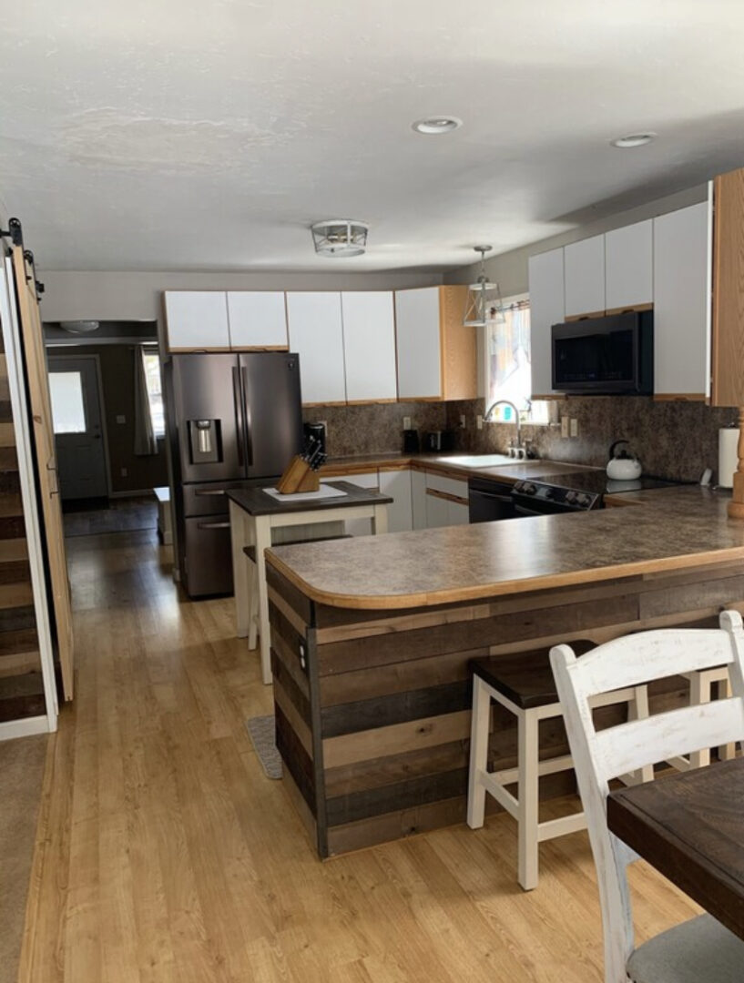 A kitchen with wooden floors and white walls.